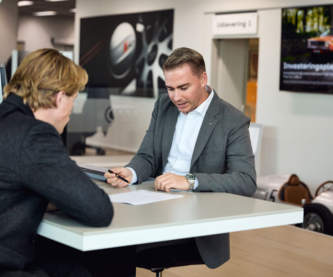 Salgsrådgiver fra Semler Mobility viser dokument frem til kunde
