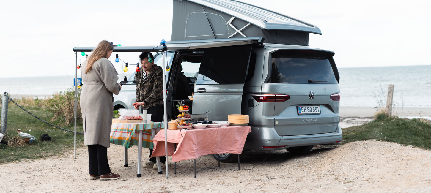 Umut og Johanne laver mad i Volkswagen California ved stranden