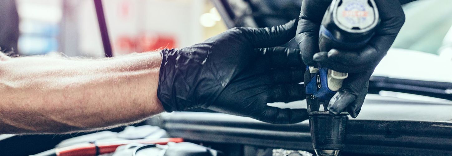 Mekanikerlærling arbejder på en bil